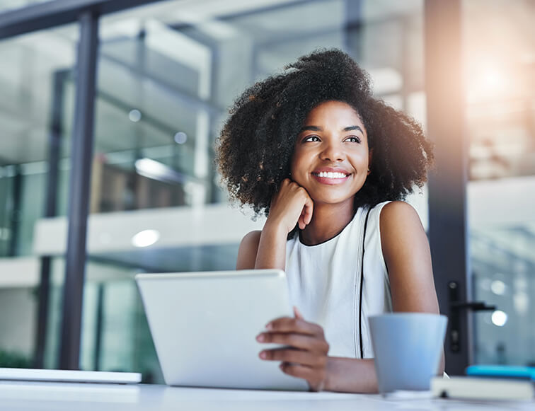 smiling woman sitting in front of her computer