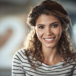 Headshot of a smiling curly-haired woman with diabetes wearing a striped shirt in jonesboro