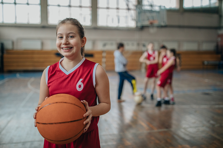 girl smilng with basketball